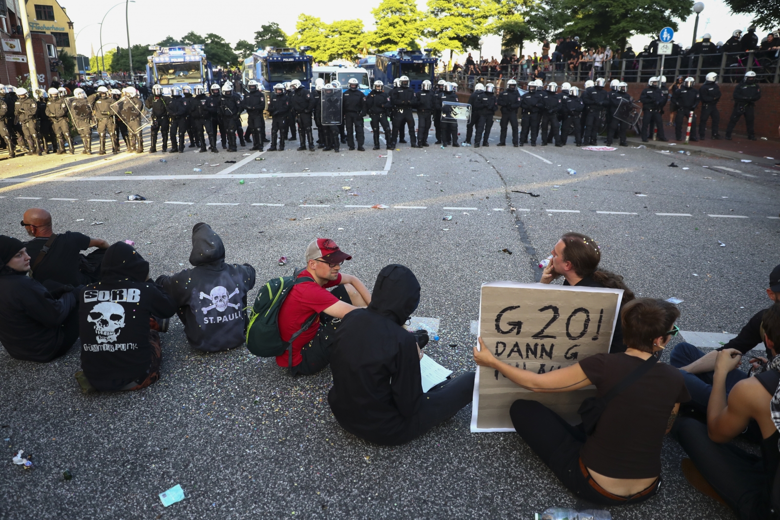 Protesters sit in front of riot police