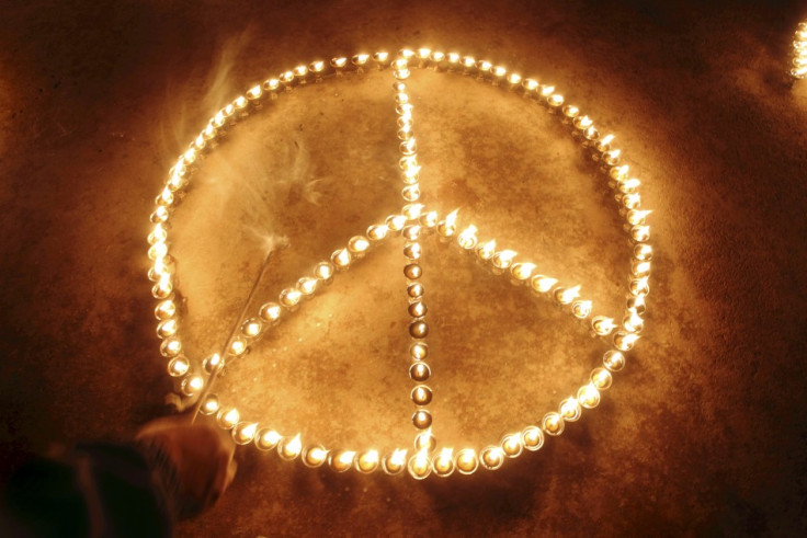 Participant&#039;s hand is seen after lighting lamps to form peace sign to commemorate victims of Japan&#039;s March 11 earthquake and tsunami, at Boudhanath Stupa in Kathmandu