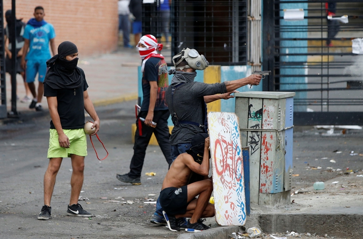 Venezuelan National Guard motorcyclists take cover upon coming under fire d...