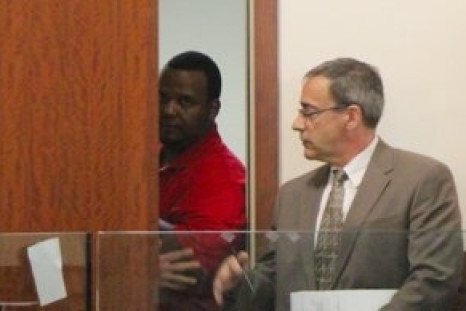 Joshua Hubert (partially behind door) is accused of throwing a seven-year-old girl off a bridge after kidnapping her