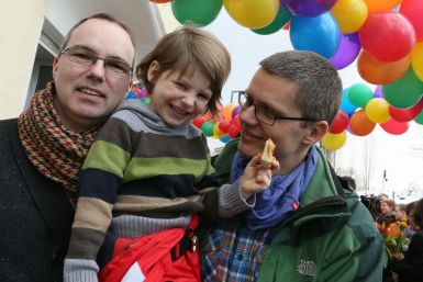 Berlin gay couple Kai (L) and Michael Korok and their daughter Jana