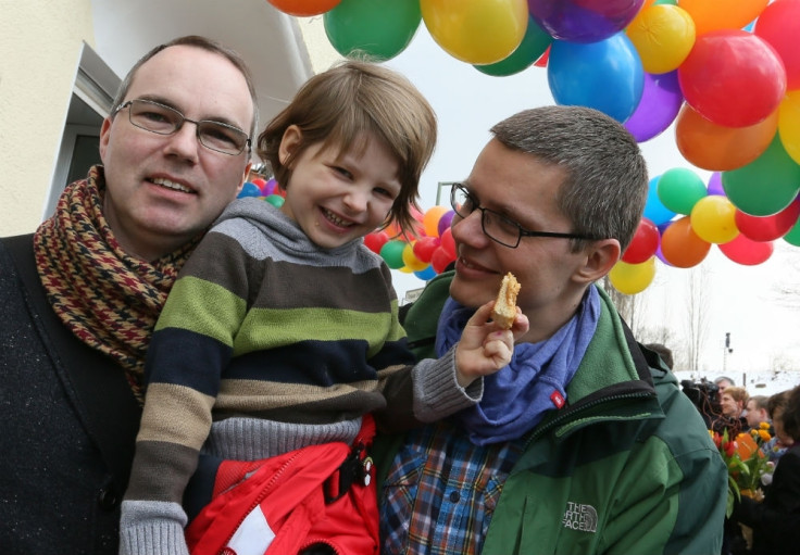 Berlin gay couple Kai (L) and Michael Korok and their daughter Jana