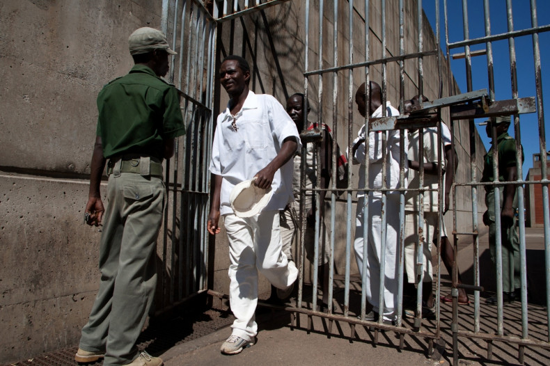Prison Inmates walk past a prison guard at the Chikurubi Maximum security prison in Harare, where the country’s hangman is expected to be based