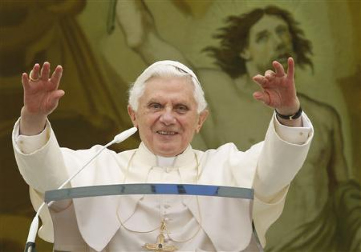 Pope Benedict XVI waves as he leads his Angelus prayer from the balcony of his summer residence in Castelgandolfo, south of Rome