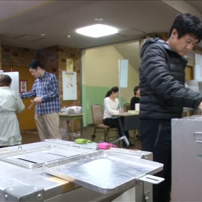 Japanese Voters Head To The Polls As Typhoon Lan Batters Country
