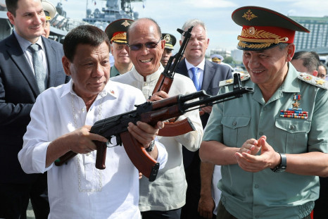 Philippine President Rodrigo Duterte (l) holds a AK-47 assault rifle as Russian Minister of Defence Sergei Shoigu looks 