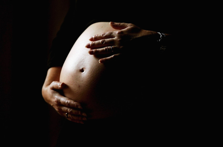 Pregnant woman holding stomach