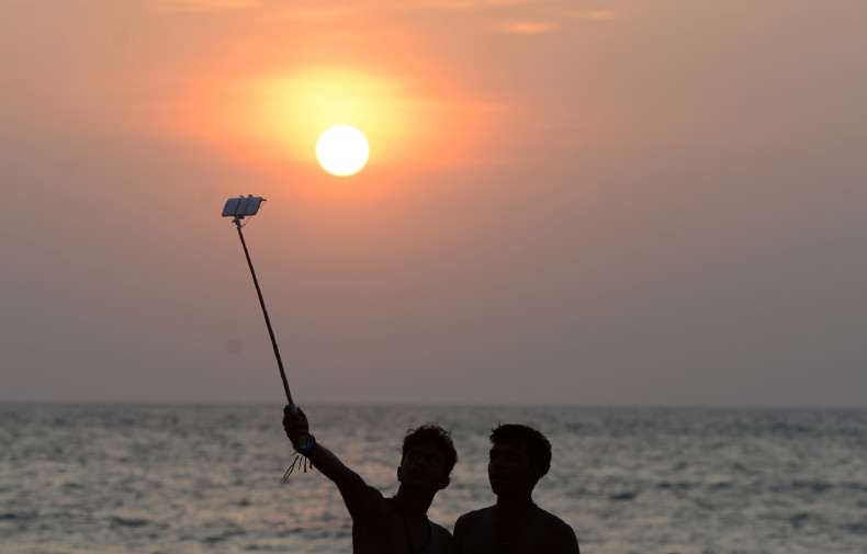 Men take a selfie by the beach