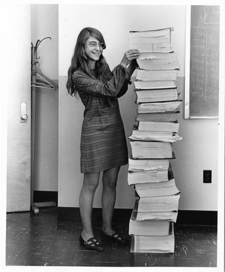 Margaret Hamilton stands beside source code