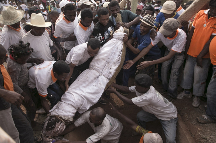 People carry a body wrapped in a sheet as they take part in a funerary tradition called the Famadihana in the village of Ambohijafy, a few kilometres from Antananarivo, on September 23, 2017. 