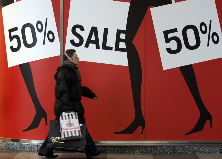 Man walks past sale shopping signs