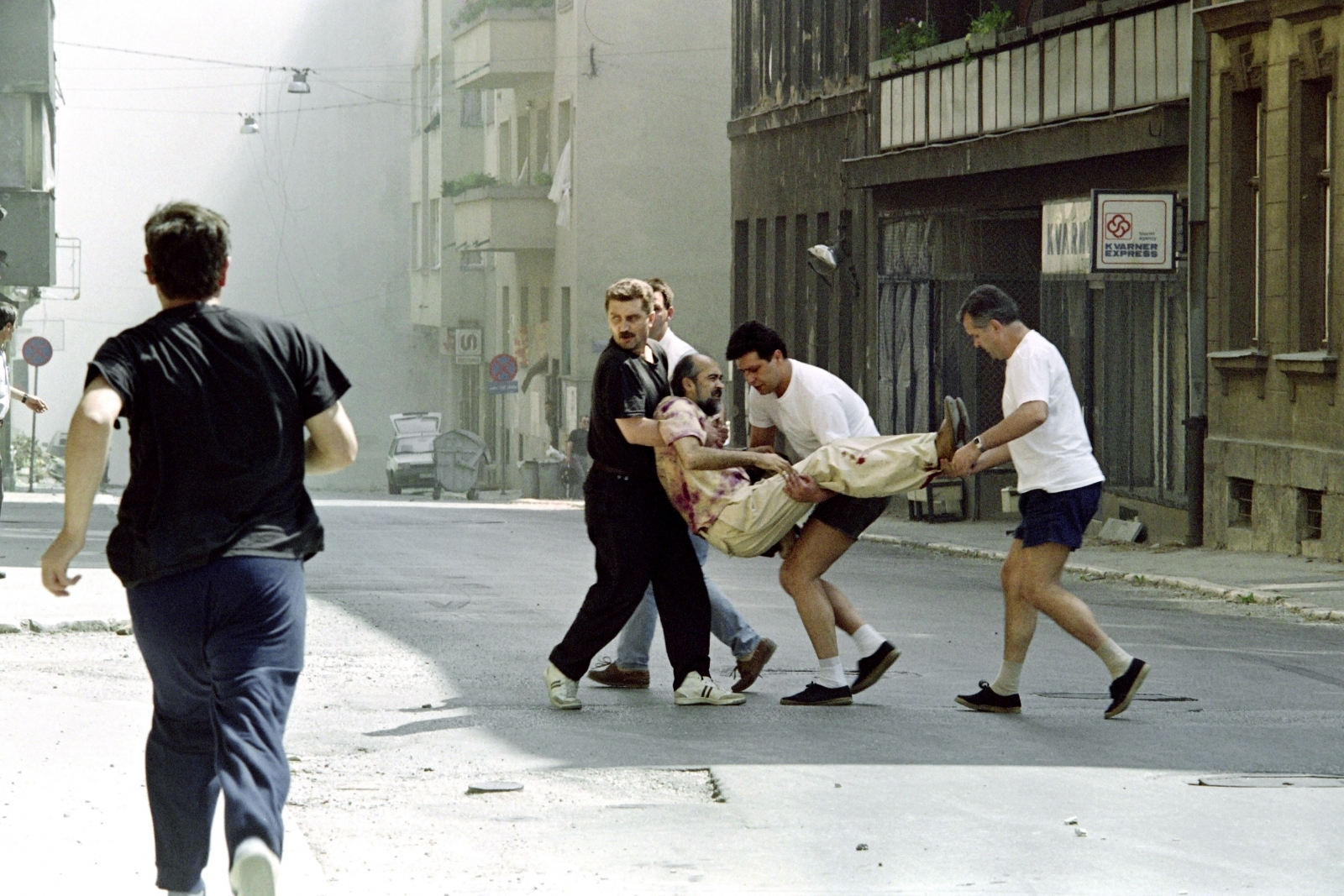 17 August 1992: People carry a civilian who was wounded during the bombardm...