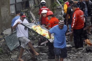 Rescuers recover a body from the rubble after strong winds brought by Typhoon Nesat, locally known as Pedring, knocked down a wall killing four residents in Valenzuela City Metro Manila 27/09/2011
