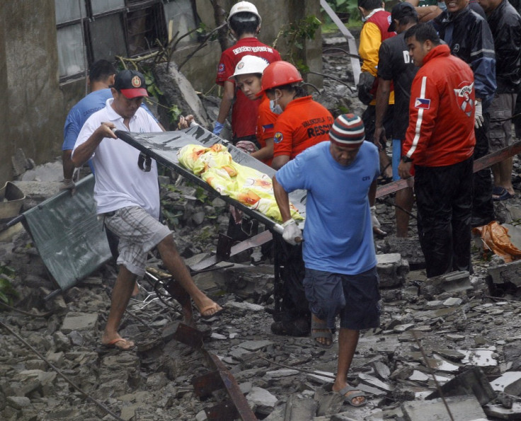 Rescuers recover a body from the rubble after strong winds brought by Typhoon Nesat, locally known as Pedring, knocked down a wall killing four residents in Valenzuela City Metro Manila 27/09/2011
