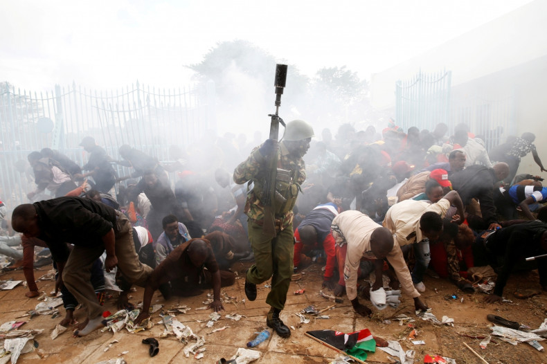 A crowd scatters as police fire tear gas to try control a crowd trying to force their way into the inauguration of President Uhuru Kenyatta at Kasarani Stadium in Nairobi, Kenya