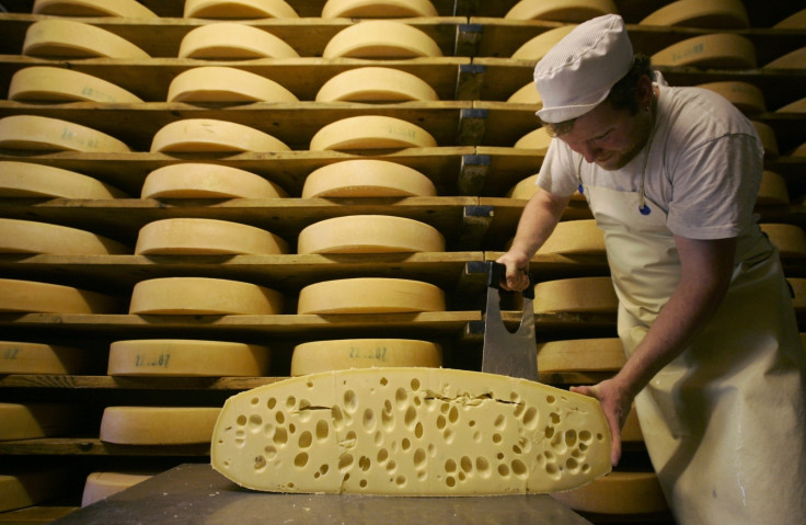 A cheese maker carves cheese