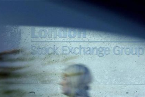 A woman is seen through a car window as she walks past the London Stock Exchange