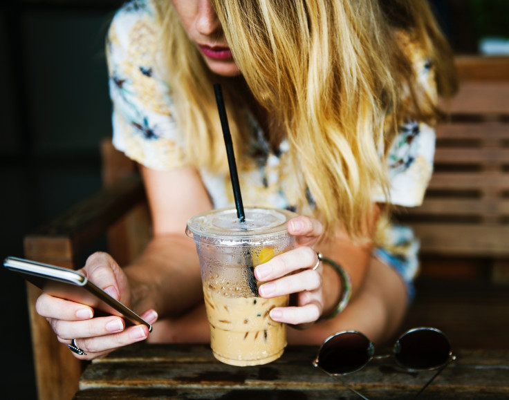 A woman drinks an iced coffee