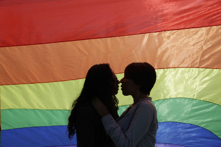Gay couple kisses by rainbow flag