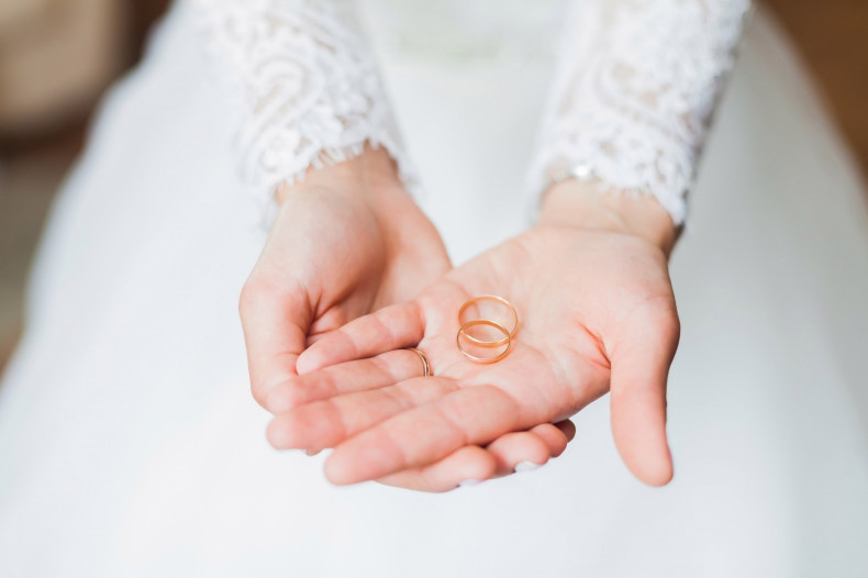 A bride holds wedding rings