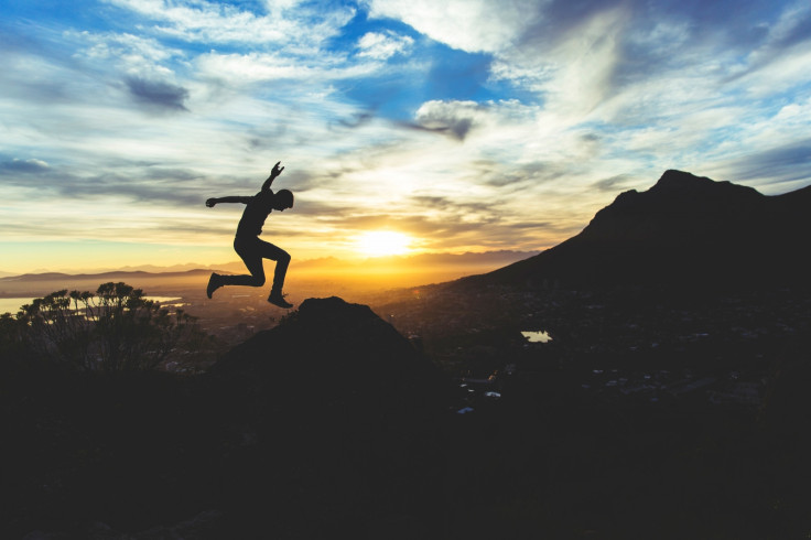 Man jumps during in front of landscape