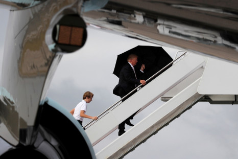 US President Donald Trump and his son Barron with his wife Melania behind (out of shot) board Air Force One as he departs West Palm Beach, Florida