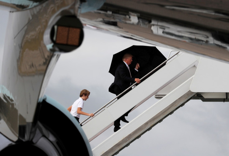 US President Donald Trump and his son Barron with his wife Melania behind (out of shot) board Air Force One as he departs West Palm Beach, Florida