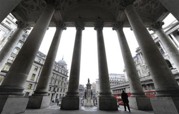 People walk through Royal Exchange with Bank of England seen behind in central London