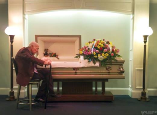 Heartbreaking picture of widower next to his wife's casket goes viral