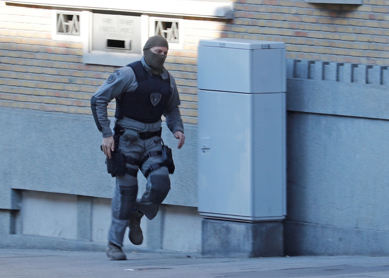 A Belgian police special forces officer runs in the Forest district after it was closed by Belgian police hunting a gunman