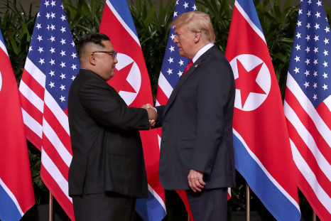Donald Trump shakes hands with Kim Jong Un