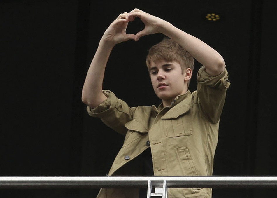 Justin Bieber greets fans from balcony of his hotel before leaving for his first My World Tour concert at Foro Sol in Mexico City