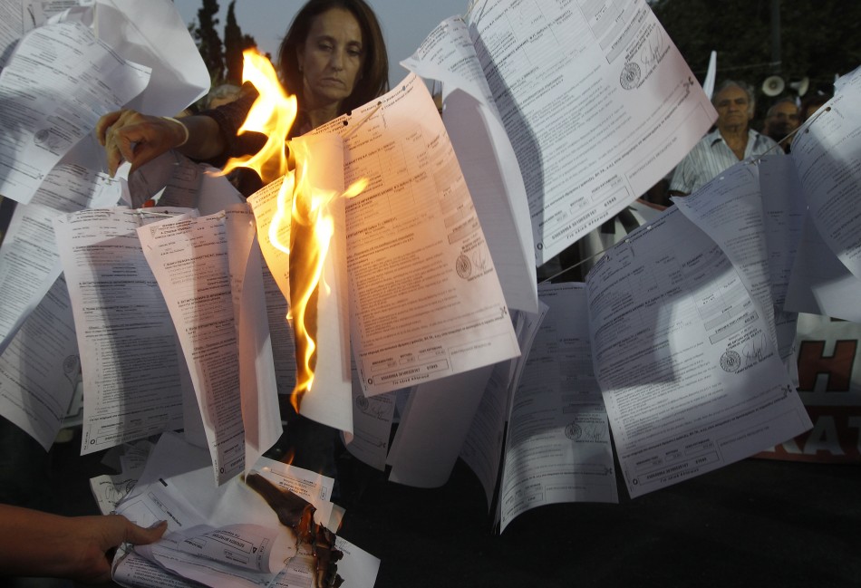 Protesters from Greek Communist-affiliated trade union PAME burn bills for new one-off income tax during rally against governments new austerity measures in Athens