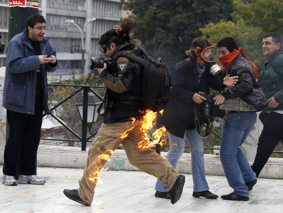 A photographer is seen in flames as he tries to escape after he caught fire from a petrol bomb during riots in front of the parliament in Athens