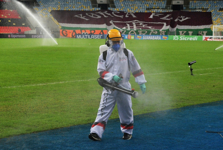 A worker disinfects the pitch in Rio