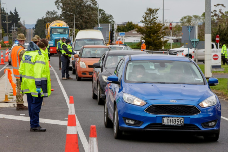 Police and military personnel check vehicles