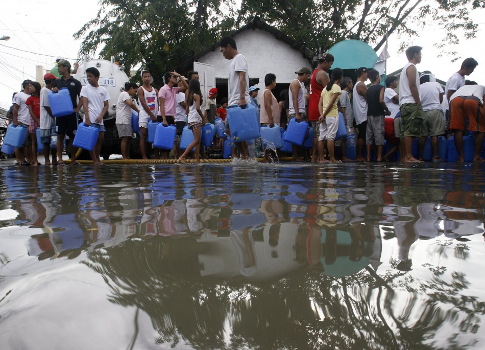 Villagers queue for drinking water at a partially flooded street in Hagonoy, Bulacan province