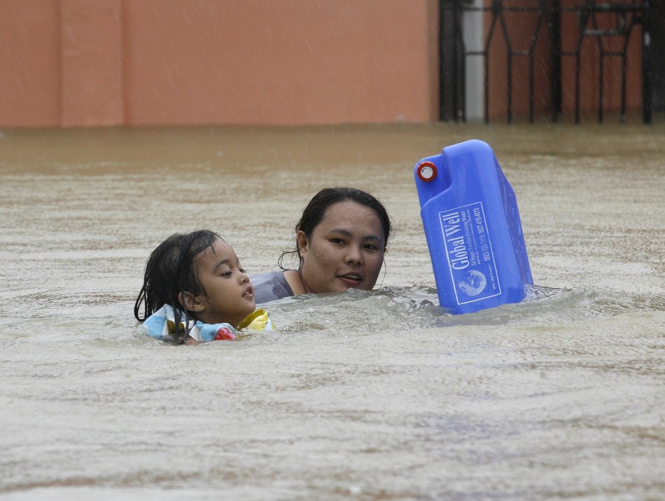 A mother And Child Wade Through Floodwater To Get Drinking Water