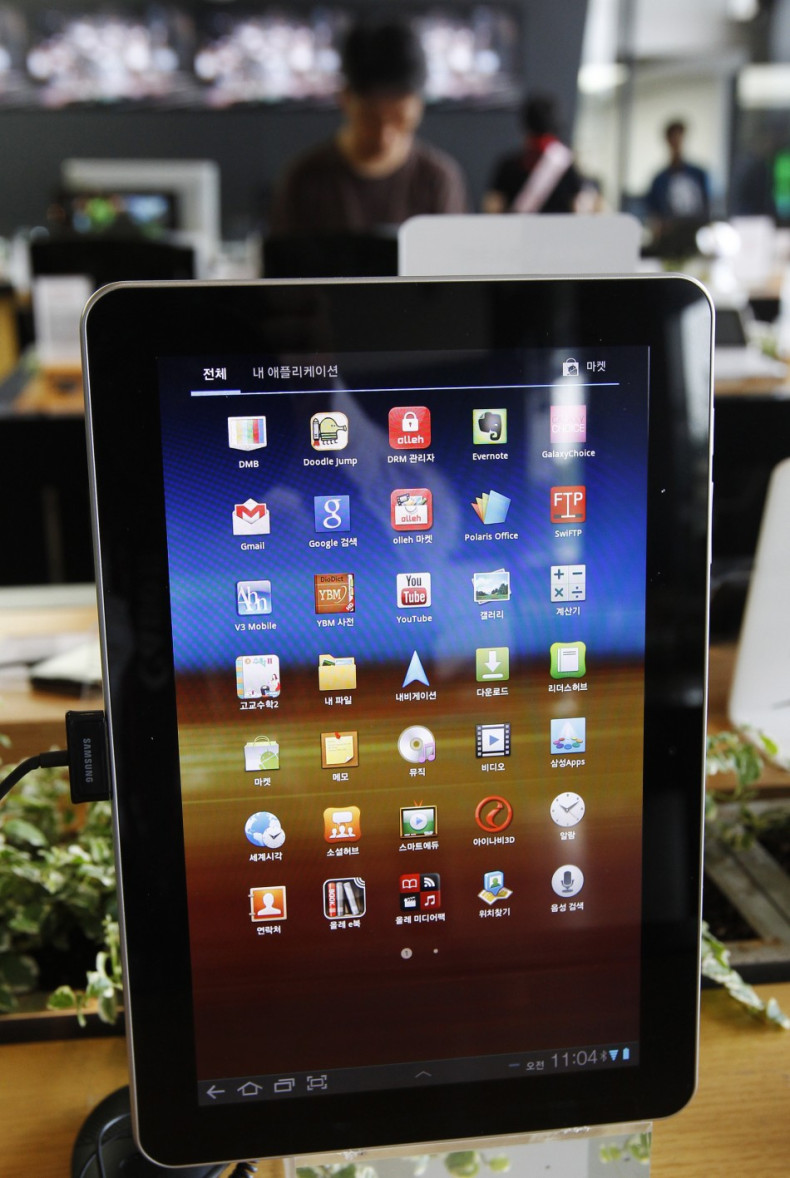 A customer looks at smartphones behind a Samsung Electronics' Galaxy Tab 10.1 on display in Seoul