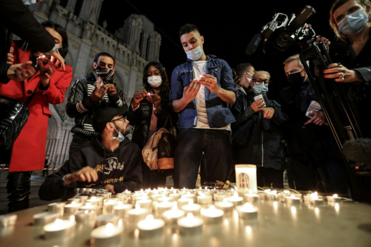 People lights candle outside the Notre-Dame