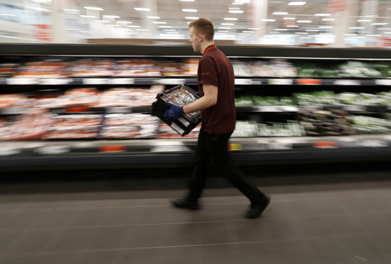 A Sainsbury's worker stacks a vegetable shelf in a store in Redhill