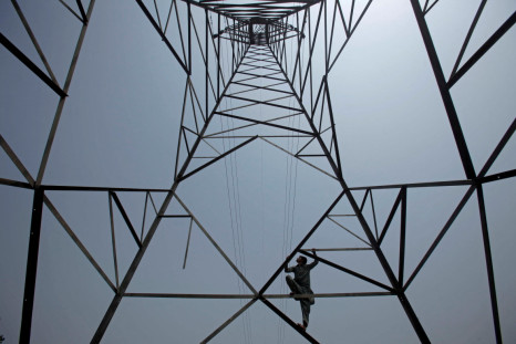 A worker of PESCO climbs up a high-voltage pylon in Peshawar