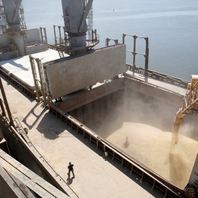 A dockyard worker watches as barley grain is poured into a ship in Nikolaev