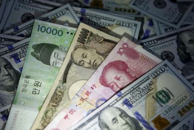 South Korean won, Chinese yuan and Japanese yen notes are seen on U.S. 100 dollar notes in this picture illustration taken in Seoul