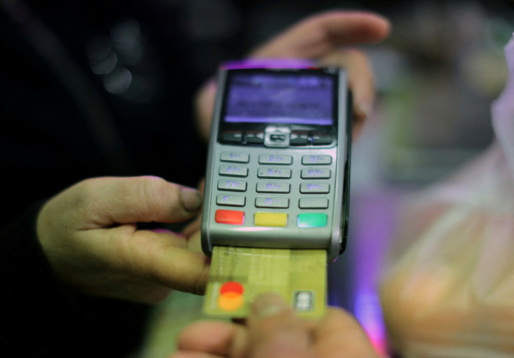 A shopper uses his credit card to pay for goods in a grocery in Nice