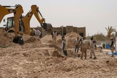 A backhoe digs up earth at the site of a mass grave, discovered by chance when property developers wanted to prepare the land for construction, in the central city of Najaf