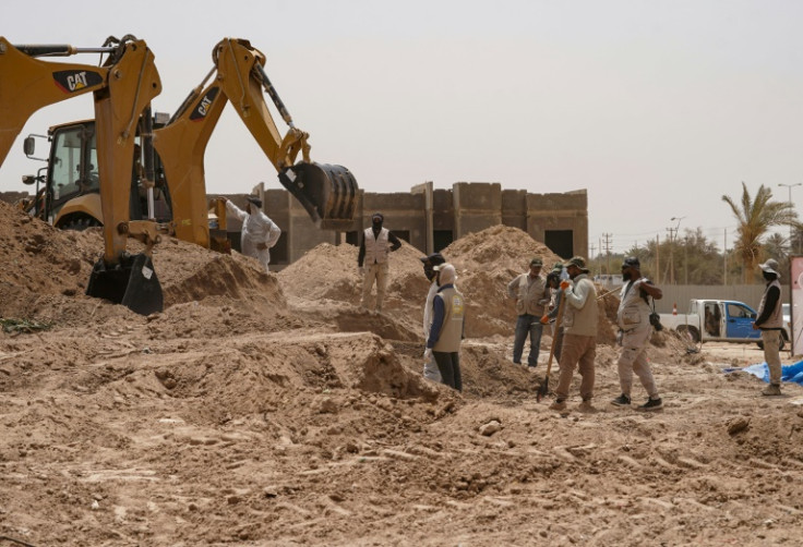 A backhoe digs up earth at the site of a mass grave, discovered by chance when property developers wanted to prepare the land for construction, in the central city of Najaf