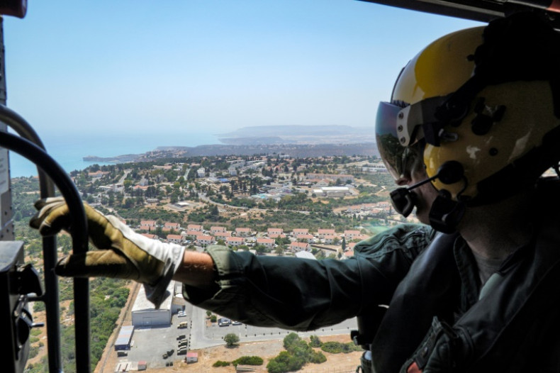 An airman of the 84 Squadron Royal Air Force looks out from a helicopter during a flight over the RAF base in Akrotiri