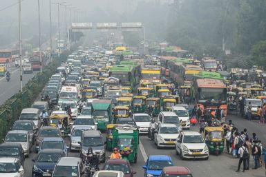 Commuters make their way along a busy road under heavy smoggy conditions in New Delhi