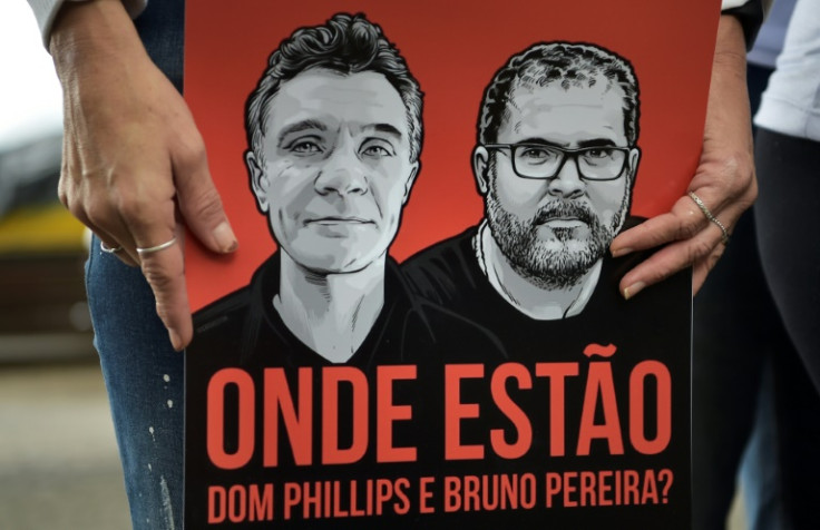 A protester in Rio de Janeiro with a banner depicting a missing British journalist and Brazilian indigenous expert, asking 'Where are Dom Phillips and Bruno Pereira?'